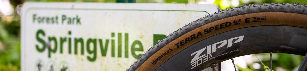 Continental Terra Speed Tire leaning on road sign.