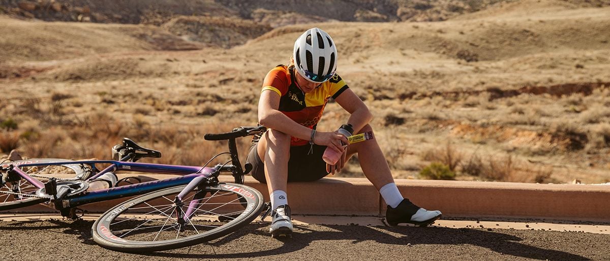 Cyclist sitting on side of road